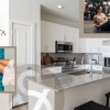 kitchen with large island and seating and a woman with her feet in the pool