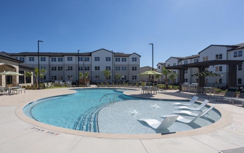 a swimming pool in front of a large building