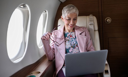 The essence of exceptional living a woman working on a laptop in a plane